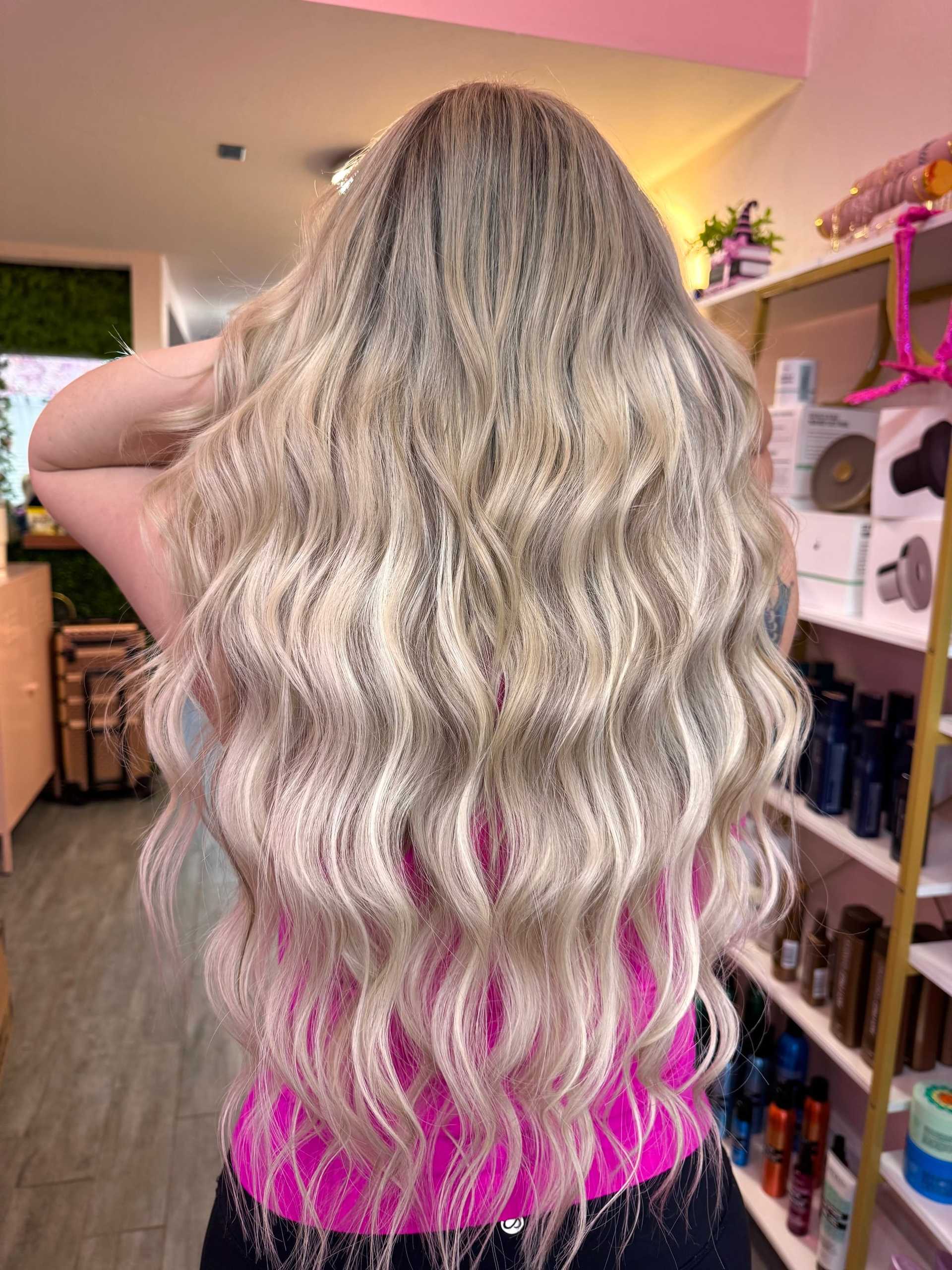 Long wavy blonde hair from the back, styled in a salon.